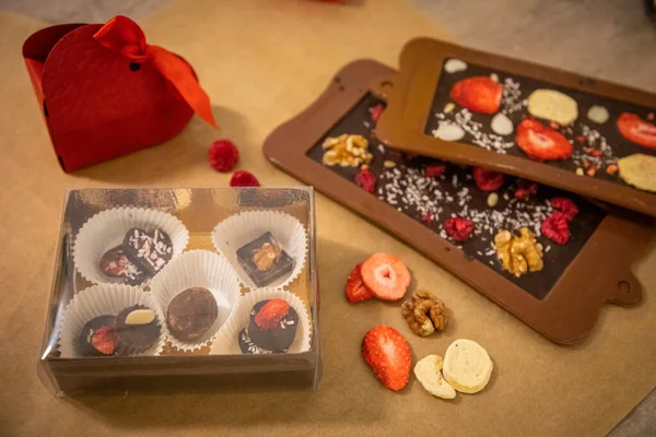 Handgemaakte chocolade met vers en gedroogd fruit op lichtpapieren ondergrond — Stockfoto