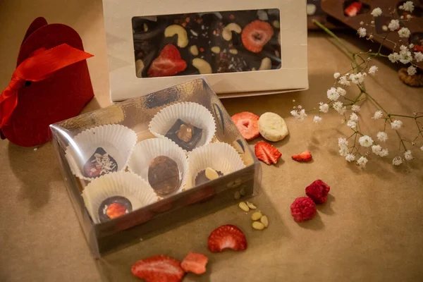 Handgemaakte chocolade met vers en gedroogd fruit op lichtpapieren ondergrond — Stockfoto