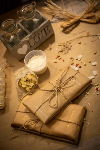 Handmade chocolate with fresh and dried fruits in wrapping on light paper background — Stock Photo, Image