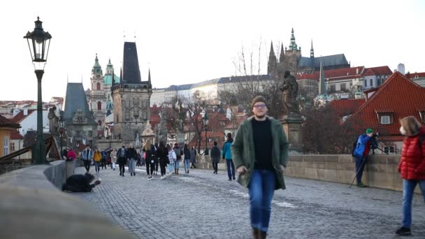 Prague, Czech Republic - 19.02.2021: Czech people on Charles bridge in winter 2021 without tourists, sunset time in Prague, Czech republic — Stock Video