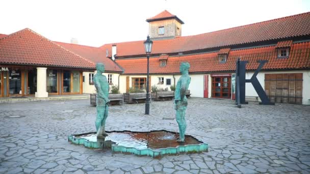 Prag, Tjeckien - 19.02.2021: Turistisk landmärke fontän med skulptur av två vuxna pissar män i vatten nära det populära museet för författaren Franz Kafka, Prag, Tjeckien — Stockvideo