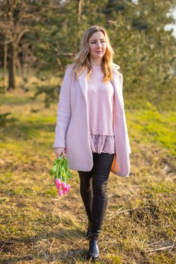 Young woman with a bouquet of tulips at the park, spring nature