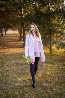 Young woman with a bouquet of tulips at the park, spring nature