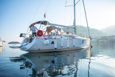 Vis, Hırvatistan - 31,03.2021: Hırvatistan 'da gün doğumunda marinada lüks bir yat