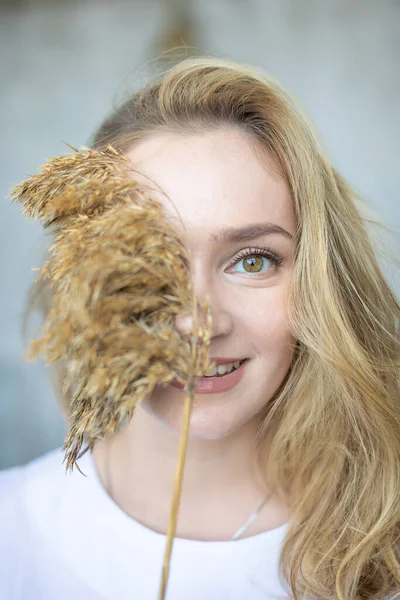 Retrato de cerca de una joven hermosa mujer con planta seca en la cara — Foto de Stock