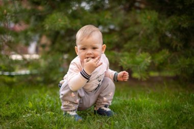 Tatlı bebeğim baharda parkta yeşil çimlerde oynuyor.