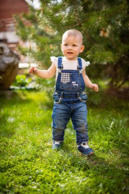 Tatlı bebeğim baharda parkta yeşil çimlerde oynuyor.