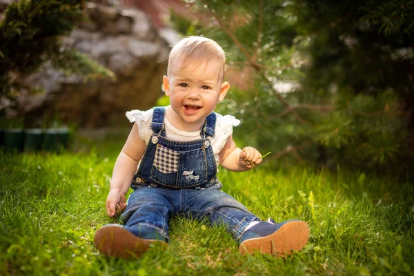 Sladké dítě dívka hrát na zelené trávě v parku na jaře — Stock fotografie