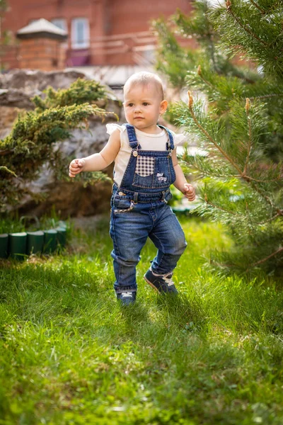 Sladké dítě dívka hrát na zelené trávě v parku na jaře — Stock fotografie