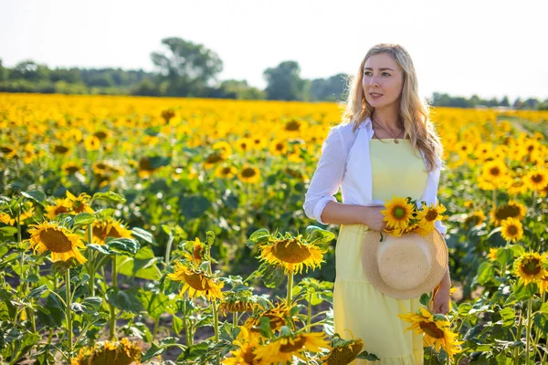 Portrait de la belle femme en tournesols sur fond de ciel — Photo