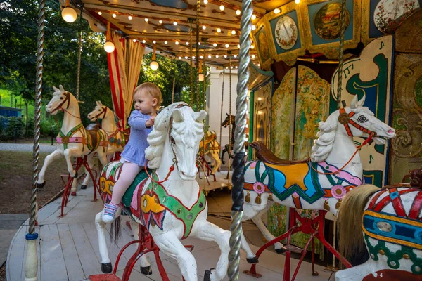 Cute baby girl on the horse of old retro carousel, Prague, Czech republic — Stock Photo, Image