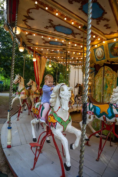 Cute baby girl on the horse of old retro carousel, Prague, Czech republic — Stock Photo, Image