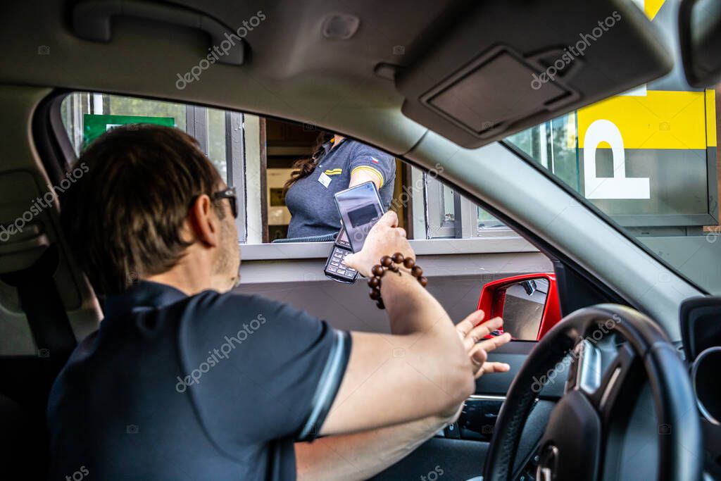 Prague, Czech Republic - 11.08.2021: McDonalds restaurant, baying meal by drive thru from the car in Prague, Czech Republic . High quality photo