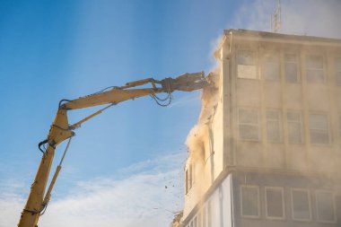 Sarı erişilebilir kazıcılı beton bir ofis binasının güçlü yıkımı. Dönüşüm, yıkım ve inşaat yenileme kavramı. Yüksek kalite fotoğraf
