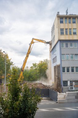 Prag, Çek Cumhuriyeti - 28 Eylül 2025: Yüksek erişimli bir kazıcı kullanarak eski bir ofis binasının yıkılması. Kentsel gelişim ve şehir dönüşümü kavramı. 