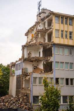 Partially demolished office building with exposed floors, walls and debris. Urban decay and architectural transformation in progress. High quality photo