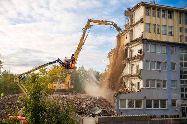 Prag, Çek Cumhuriyeti - 28 Eylül 2025: Yüksek erişimli bir kazıcı kullanarak eski bir ofis binasının yıkılması. Kentsel gelişim ve şehir dönüşümü kavramı. 