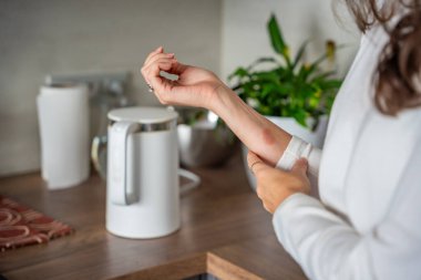 Mutfaktaki su ısıtıcısından çıkan buharın yol açtığı kafa derisi yanığı. Sıcak ev aletlerinin tehlikesini gösteren bir ev kazası. Yüksek kalite fotoğraf
