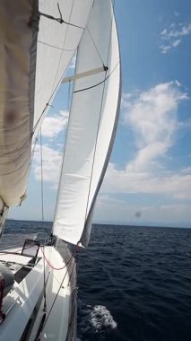 Denizi yarıp geçen bir yatın yanında Hırvatistan yakınlarında yelkenler açılıyor. Hareket, özgürlük, yelkencilik yaşam tarzı ve açık denizde macera. Yüksek kalite 4k görüntü