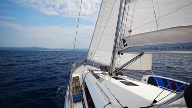 Split, Hırvatistan - 14 Haziran 2025: Tüm yelkenler Hırvatistan yakınlarındaki açık denizde son sürat giden bir yat. Dinamik deniz macerası ve okyanus yolculuğu özgürlüğü. Yüksek kalite 4k görüntü