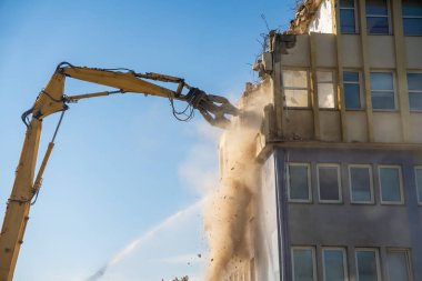 Sarı erişilebilir kazıcılı beton bir ofis binasının güçlü yıkımı. Dönüşüm, yıkım ve inşaat yenileme kavramı. Yüksek kalite fotoğraf