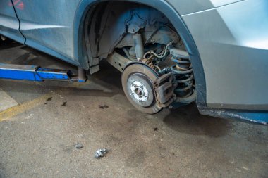 Mevsimsel bakım sırasında lastikleri söküldükten sonra ortaya çıkan araba tekerleği merkezi ve fren diski. Yol güvenliği ve teknik denetim için kış lastiği değişiminin temel aşaması. Yüksek kalite fotoğraf