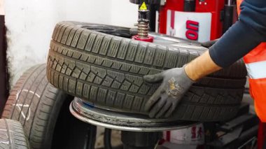 Tamirci lastik lastiği değiştirdikten sonra lastiği teker makinesiyle değiştirmiş. Kış hazırlıkları sırasında mevsimsel lastik değiştirme manüel aşamasında. Yüksek kalite 4k görüntü