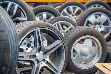Araba atölyesinde arka arkaya dizilmiş lastikleri olan farklı araba tekerlekleri. Çek Cumhuriyeti 'nde kış hazırlıkları için mevsimlik lastik değiştirme ve servis. Yüksek kalite fotoğraf