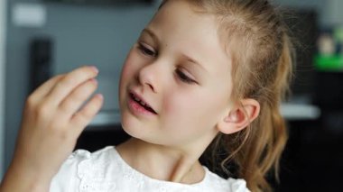 Gülümseyen kız kaybettiği bebek dişini gururla gösteriyor, neşeli yüzüne odaklanıyor. Çocukluğun dönüm noktasını ve duygusal gelişim anını kutluyoruz. Yüksek kalite 4k görüntü