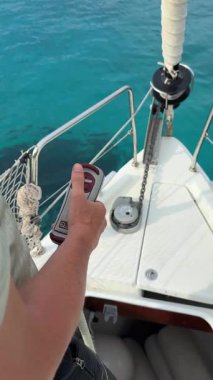 Hvar, Hırvatistan - 23 Temmuz 2025: Demirleme sırasında uzaktan kumandayla bir yatta otomatik çapa zinciri alımı. Windlass sistemi iş başında, modern yelkencilik yaşamından ve denizcilik rutininden ayrıntılar.