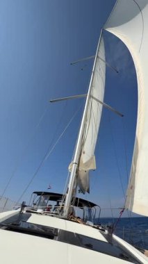 Lastovo, Hırvatistan - 14 Haziran 2025: Hırvatistan yakınlarındaki bir yatın pruvasından görülen rüzgar dolu beyaz yelkenliler. Özgürlük, temiz enerji, macera ve açık denizde dikkatli bir yolculuk.. 