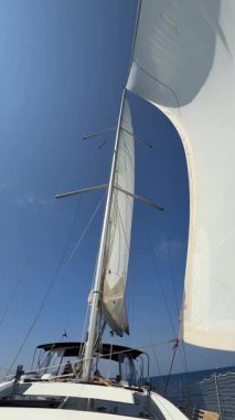 Lastovo, Hırvatistan - 14 Haziran 2025: Hırvatistan yakınlarındaki bir yatın pruvasından görülen rüzgar dolu beyaz yelkenliler. Özgürlük, temiz enerji, macera ve açık denizde dikkatli bir yolculuk.. 