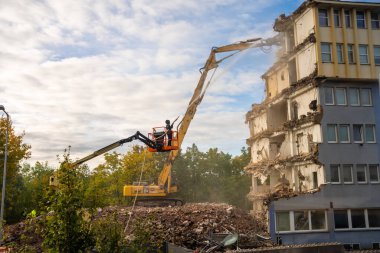 Prag, Çek Cumhuriyeti - 28 Eylül 2025: Yüksek erişimli bir kazıcı kullanarak eski bir ofis binasının yıkılması. Kentsel gelişim ve şehir dönüşümü kavramı. 