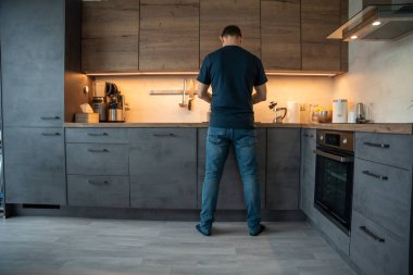 Adam sobaya bakarken mutfakta yemek hazırlıyor. Ev yemeği hazırlığı.