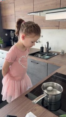 Paskalya yumurtalarını evde kaynatmak için hazırlayan genç bir kız. Bu görüntü geleneksel aile ritüellerini ve bağımsızlık duygusunu yansıtıyor..