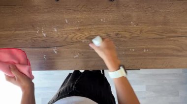 Mutfak tezgahını temizleme solüsyonuyla spreylemenin ve tamamen bezle silmenin en üst görüntüsü. Derin yüzey temizleme rutini ve hijyen odaklı bakım konsepti