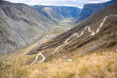 Katu Yaryk geçidi ve Altai Rusya 'da nehir olan Chulyshman Vadisi' ne giden dağ yolunun üst manzarası kıvrımlı rotası ve derin kanyonu olan dramatik dağlık arazi. Yüksek kalite fotoğraf