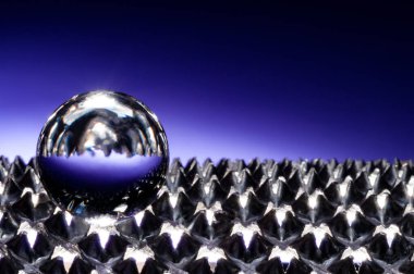 Kopyalama alanı yakın görünümü ile knurlu yüzeyde cam küre ile aşağılayıcı mavi arkaplan