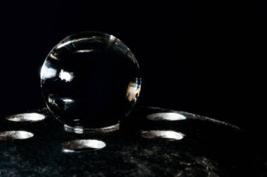 Metal ızgara desteğinde kopyalama alanı olan siyah arkaplanda kristal küre