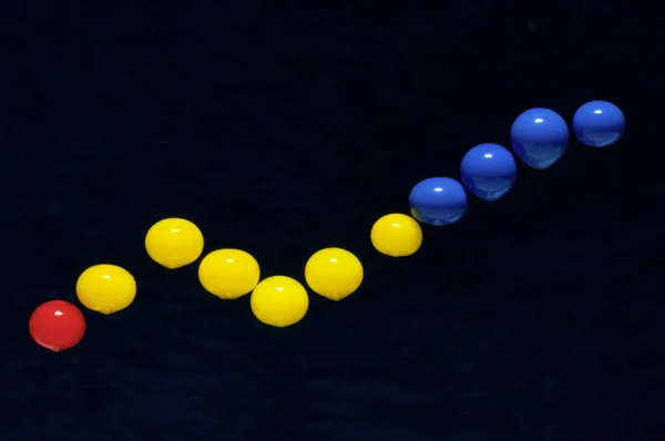 Plastik renkli iğne başlıkları siyah arkaplan üzerine iş grafiğinin bir temsili