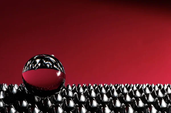 Kırmızı arkaplanda cam küre ile knurled yüzeyde kopyalama alanı