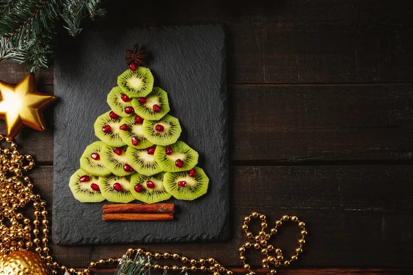  Kivi ve nar Noel ağacı, yeni yıl yemeği konsepti. Metin için boş alan