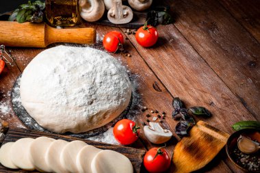 Pizza yapmak için gerekli malzemeler - hamur, mozzarella peyniri, domates, mantar ve ahşap arka planda fesleğen. Metin için boş alan. Yüksek kalite fotoğraf