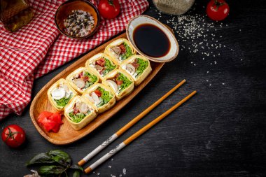  Siyah zemin üzerinde tavuk ve krem peynirli japon dürümleri ve metin için boş yer. Yüksek kalite fotoğraf