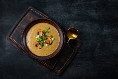  Siyah zemin üzerinde ev yapımı mantar kremalı çorba tabağı, üst manzara, yazı için boş yer. Yüksek kalite fotoğraf