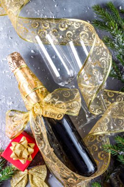 Şampanya şişesi ve iki bardak kar ve noel süsü, üst manzara, dikey fotoğraf. Yüksek kalite fotoğraf