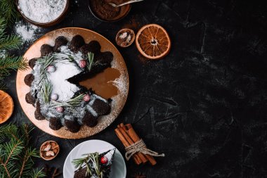  Siyah arka planda böğürtlen ve biberiyeyle süslenmiş Noel çikolatalı pasta, üst manzara, yazı için boş yer. Yüksek kalite fotoğraf