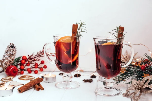 Two glasses of hot homemade mulled wine with oranges and rosemary in a New Years atmosphere — Stock Photo, Image