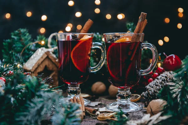 Ζεστό σπιτικό ζεστό κρασί με πορτοκάλια και κανέλα σε ατμόσφαιρα Πρωτοχρονιάς, σκούρα φωτογραφία — Φωτογραφία Αρχείου