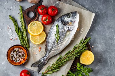 Çiğ dorado balığı ve baharatlar, gri arka planda pişirmek için, üst manzara. Yüksek kalite fotoğraf